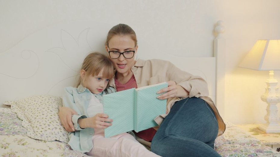 родитель читает книгу ребенку перед сном