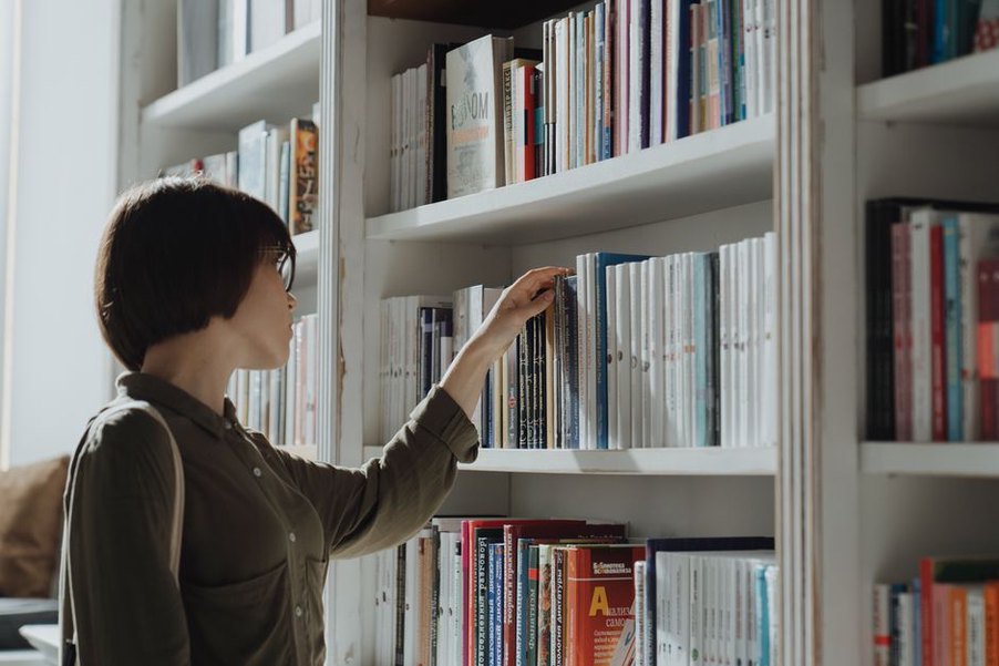 ребенок выбирает книгу с полки