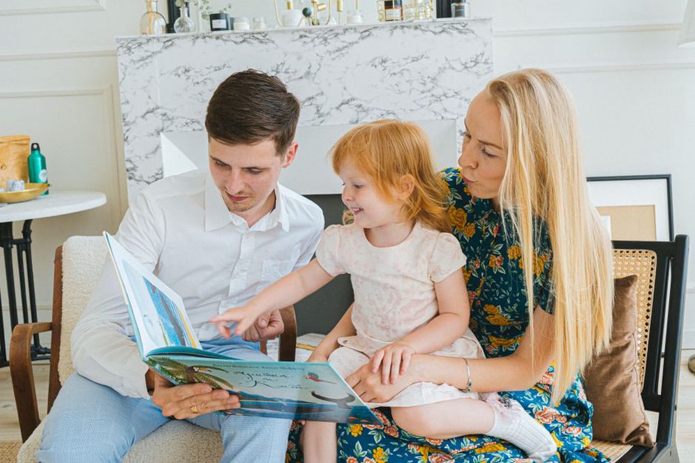 семья читает книги у камина