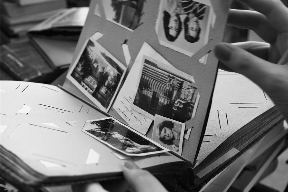 Ребёнок вклеивает семейные фотографии в альбом